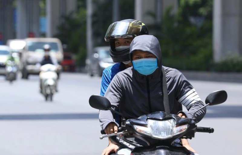  Người dân Hà Nội mặc kín mít khi phải di chuyển trên đường giữa trời nắng nóng. (Ảnh: Hoàng Hiếu/TTXVN)
