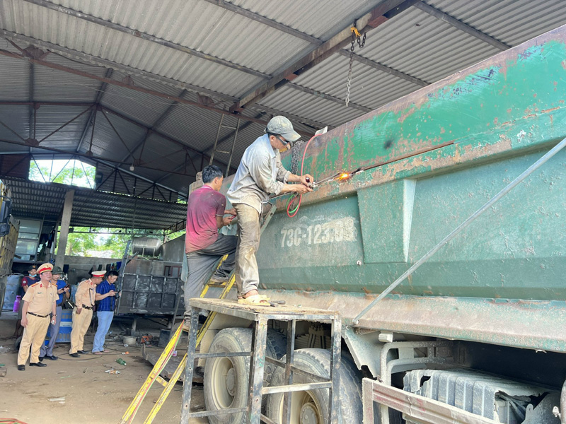 Lực lượng CSGT thuộc Phòng CSGT giám sát việc cắt bỏ phần thành thùng xe có vi phạm.