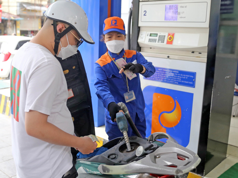 Người dân mua xăng dầu sau khi điều chỉnh giá mới tại một cửa hàng của Petrolimex. Ảnh: Trần Việt - TTXVN