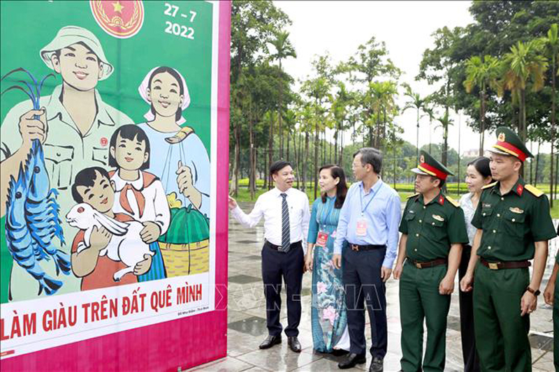 Các đại biểu tham quan Triển lãm tranh cổ động toàn quốc tuyên truyền kỷ niệm 75 năm ngày Thương binh Liệt sỹ. Ảnh: Hoàng Hùng/TTXVN