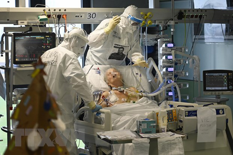 Nhân viên y tế điều trị cho bệnh nhân COVID-19. (Ảnh: AFP/TTXVN)