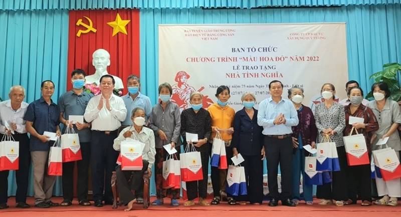 Đồng chí Nguyễn Trọng Nghĩa, Bí thư Trung ương Đảng, Trưởng Ban Tuyên giáo Trung ương và đồng chí Lại Xuân Môn, Ủy viên Trung ương Đảng, Phó Trưởng Ban Thường trực Ban Tuyên giáo Trung ương trao tặng quà tình nghĩa trong chương trình Màu hoa đỏ cho các gia đình chính sách tại thị xã Gò Công, tỉnh Tiền Giang. 