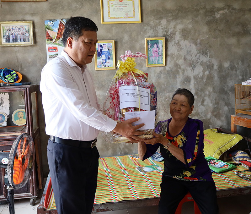 Đồng chí Trần Phong, Ủy viên Ban Thường vụ Tỉnh ủy, Bí thư Thành ủy Đồng Hới tặng quà thương binh Bùi Thị Nhụ.