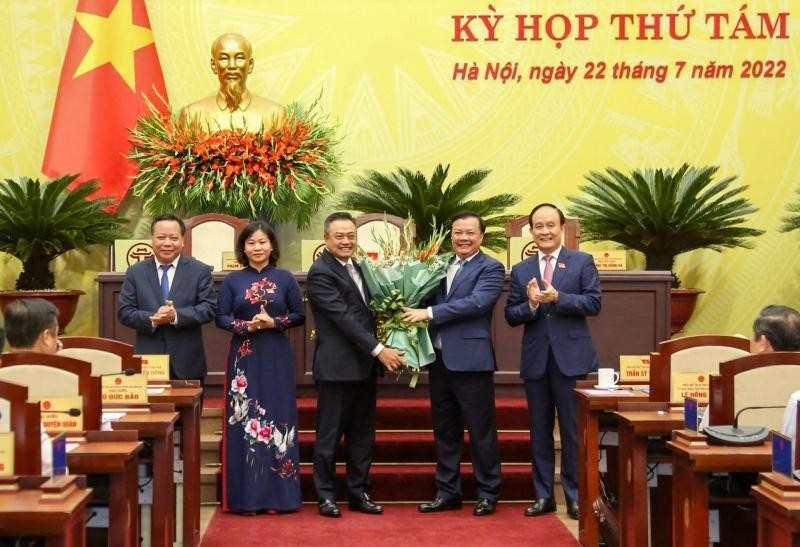 Bí thư Thành ủy Đinh Tiến Dũng và các đồng chí lãnh đạo thành phố tặng hoa chúc mừng tân Chủ tịch Ủy ban nhân dân thành phố Hà Nội Trần Sỹ Thanh. (Ảnh Duy Linh)