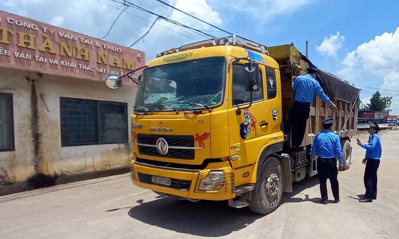 Thanh tra giao thông đang xử lý xe ô tô chở hàng có dấu hiệu quá tải trọng.