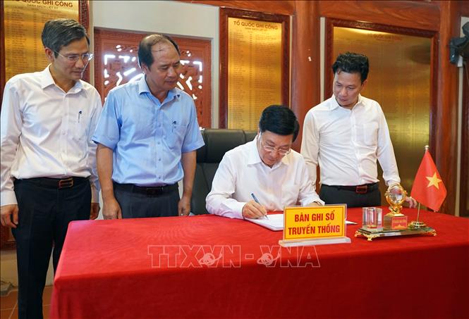 Phó Thủ tướng Thường trực Phạm Bình Minh ghi sổ vàng lưu niệm tại Nghĩa trang Liệt sỹ quốc gia Vị Xuyên. 