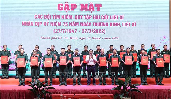 Thủ tướng Phạm Minh Chính tặng quà cho đại diện các đội tìm kiếm, quy tập hài cốt liệt sĩ. Ảnh: Dương Giang/TTXVN