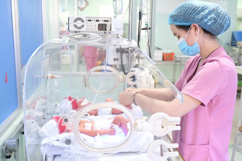 Nhân viên y tế chăm sóc cho trẻ sơ sinh. (Ảnh: TTXVN phát)