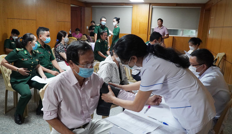 Các đối tượng được cán bộ y tế tư vấn và khám sàng lọc kỹ trước khi tiêm vắc xin phòng Covid-19 mũi 4.