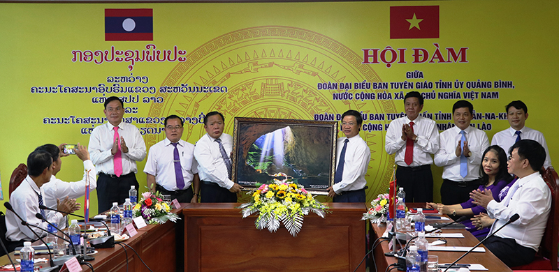 Đồng chí Trưởng ban Tuyên giáo Tỉnh ủy Cao Văn Định tặng bức tranh hang Sơn Đoòng cho Ban Tuyên huấn tỉnh Sạ-vẳn-na-khệt.