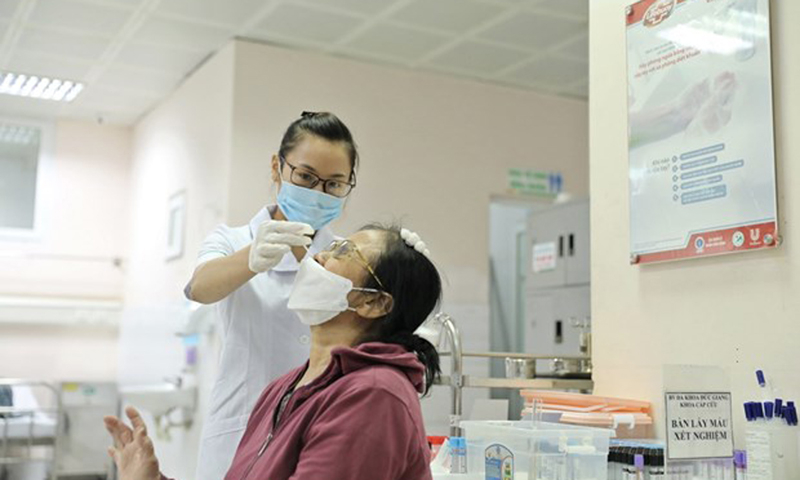 Nhân viên y tế lấy mẫu xét nghiệm cho người dân. (Ảnh: Minh Quyết/TTXVN)