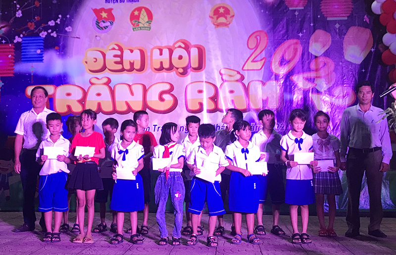 Đại diện lãnh đạo xã Nam Trạch (Bố Trạch) trao quà cho các em học sinh.