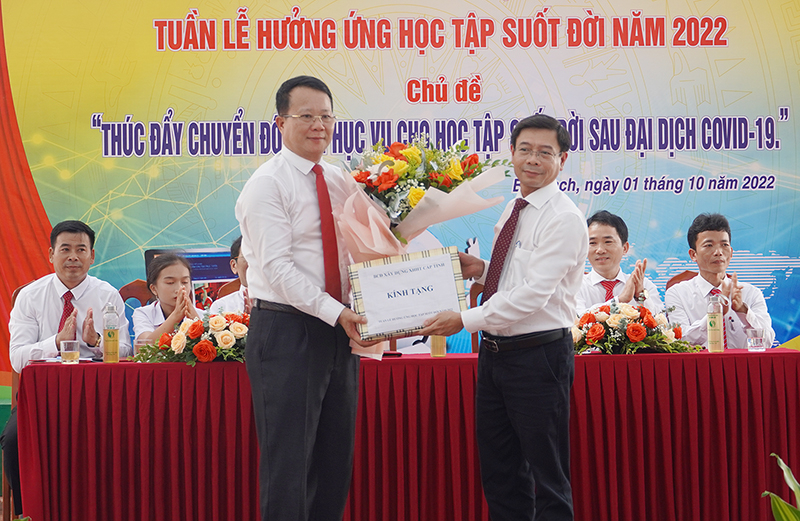 Đại diện Ban Chỉ đạo Xây dựng xã hội học tập tỉnh tặng hoa chúc mừng lễ phát động “Tuần lễ học tập suốt đời”  của huyện Bố Trạch.
