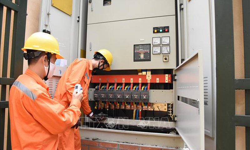 Các công nhân EVNHANOI kiểm tra mối nối cấp điện trên địa bàn Hà Nội. Ảnh: TTXVN phát