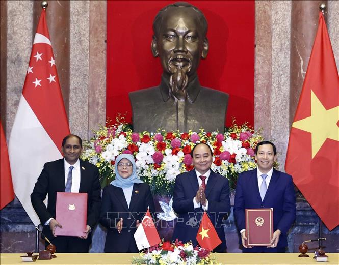 Chủ tịch nước Nguyễn Xuân Phúc và Tổng thống Singapore Halimah Yacob chứng kiến lễ ký Bản ghi nhớ hợp tác an ninh mạng, phòng chống tội phạm mạng, bảo vệ dữ liệu cá nhân giữa Bộ Công an Việt Nam và Bộ Truyền thông và Thông tin Singapore. Ảnh: Thống Nhất/TTXVN