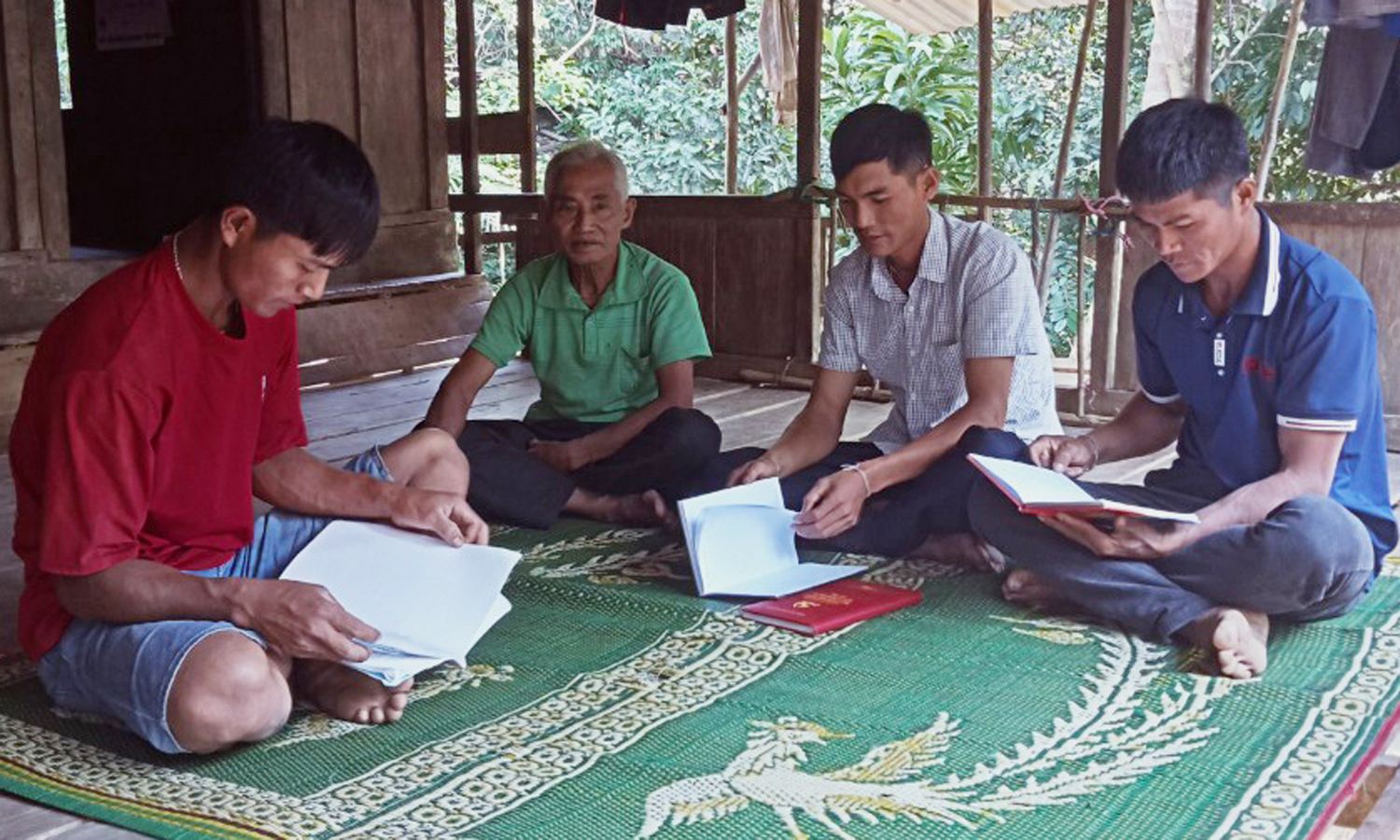 Bí thư Chi bộ bản Ông Tú Hồ Thay (ngồi thứ 2 từ phải qua) đang triển khai các nghị quyết cho đảng viên trong bản.