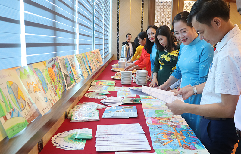 Các đại biểu tham quan gian trưng bày các tác phẩm đạt giải cuộc thi vẻ tranh “Cùng em bảo vệ môi trường trong lành” của học sinh tại 2 xã dự án.