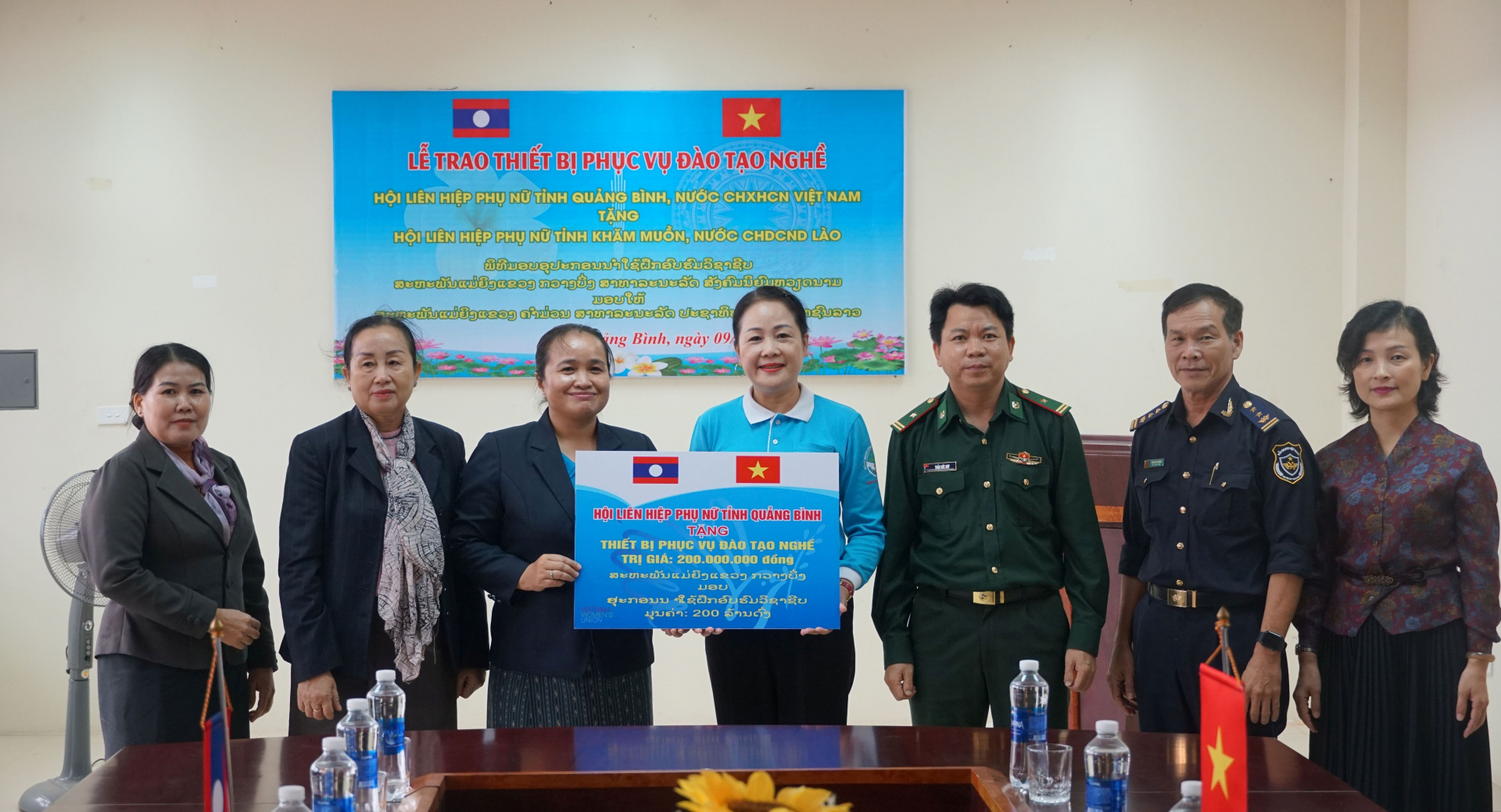 : Lãnh đạo Hội LHPN tỉnh Quảng Bình trao tượng trưng món quà là các trang thiết bị đào tạo nghề cắt may, trang điểm cho Hội LHPN tỉnh Khăm Muồn.
