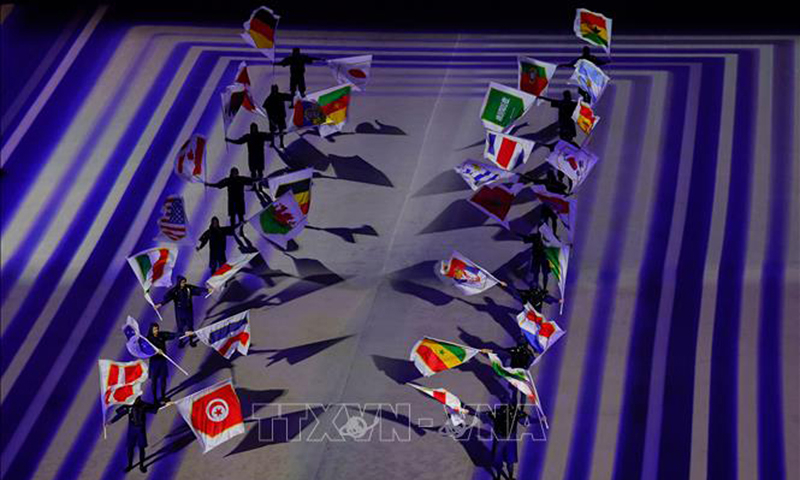 Các nghệ sĩ trình diễn quốc kỳ của 32 đội tuyển tham gia tranh tài tại World Cup 2022 trong lễ khai mạc giải đấu, trên sân Al-Bayt ở Al Khor, Qatar ngày 20/11/2022. Ảnh: AFP/TTXVN