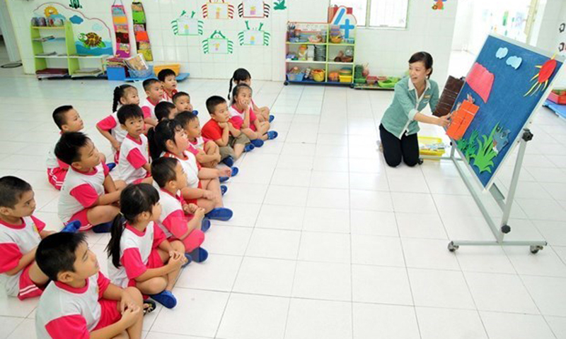 Làm việc vất vả, nhiều áp lực nhưng thu nhập thấp đang là thực trạng của giáo viên mầm non.(Ảnh: TTXVN)