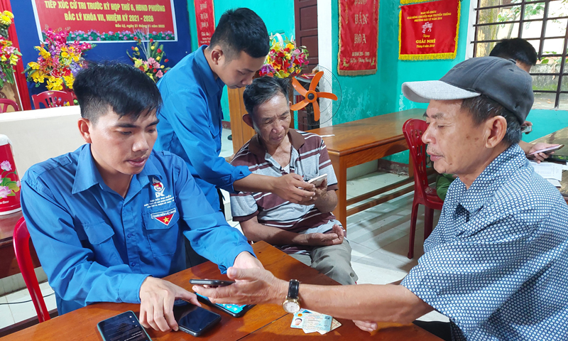 Đoàn viên, thanh niên phường Bắc Lý (TP.Đồng Hới) hỗ trợ người dân cài đặt ứng dụng VNeID. 