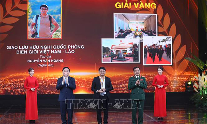Đại tướng Phan Văn Giang và Trưởng Ban Tuyên giáo Trung ương Nguyễn Trọng Nghĩa trao Cup và Huy chương Vàng cho tác giả Nguyễn Văn Hoàng (Nghệ An) tác phẩm “Giao lưu hữu nghị Quốc phòng Việt Nam - Lào”. Ảnh: Hoàng Hiếu/TTXVN