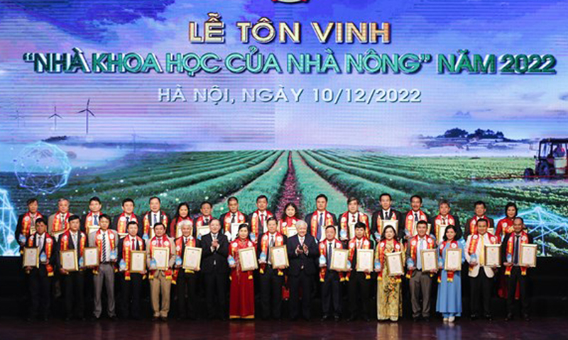 Ông Đỗ Văn Chiến - Bí thư Trung ương Đảng, Chủ tịch Ủy ban Trung ương Mặt trận Tổ quốc Việt Nam; ông Lương Quốc Đoàn - Ủy viên Trung ương Đảng, Chủ tịch Ban Chấp hành Trung ương Hội Nông dân Việt Nam chụp ảnh kỷ niệm cùng các nhà khoa học của nhà nông năm 2022. (Nguồn: Dân Việt)