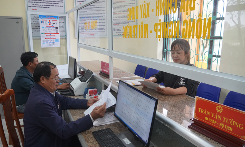 Người dân giao dịch tại bộ phận “Một cửa” UBND xã Vĩnh Ninh (Quảng Ninh).