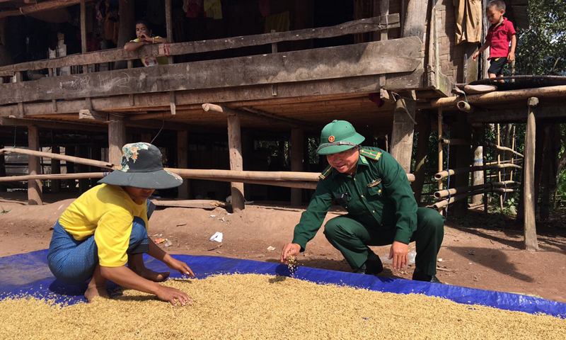 Thiếu tá Trương Tấn Hợp giúp đồng bào Ma Coong phơi lúa.