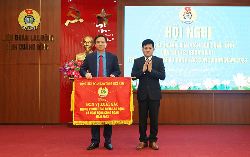 Đồng chí Trưởng ban Dân vận Tỉnh ủy Lê Văn Bảo trao cờ đơn vị xuất sắc trong phong trào thi đua năm 2022 cho LĐLĐ tỉnh