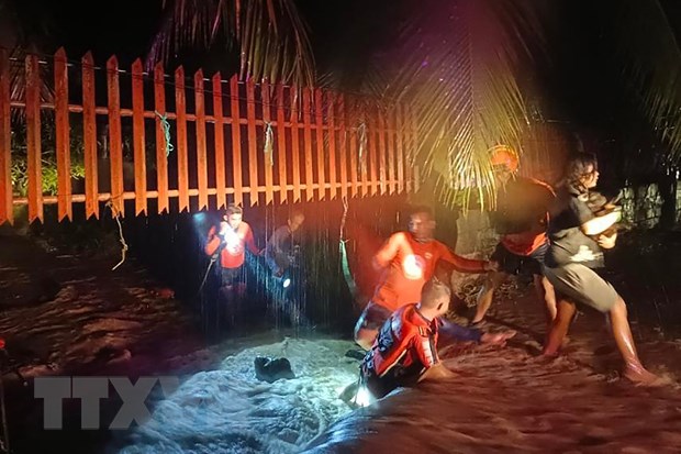 Lực lượng cứu hộ sơ tán người dân khỏi vùng ngập lụt tại thành phố Ozamiz, Philippines ngày 25/12/2022. (Ảnh: AFP/TTXVN)