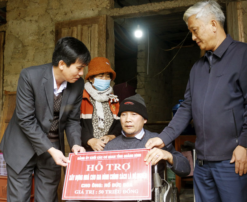  Đồng chí Nguyễn Thanh Lam, Bí thư Đảng ủy Khối các cơ quan tỉnh trao biển tượng trưng cho gia đình ông Hồ Đức Đóa ở thôn 1, xã Mỹ Trạch (Bố Trạch).
