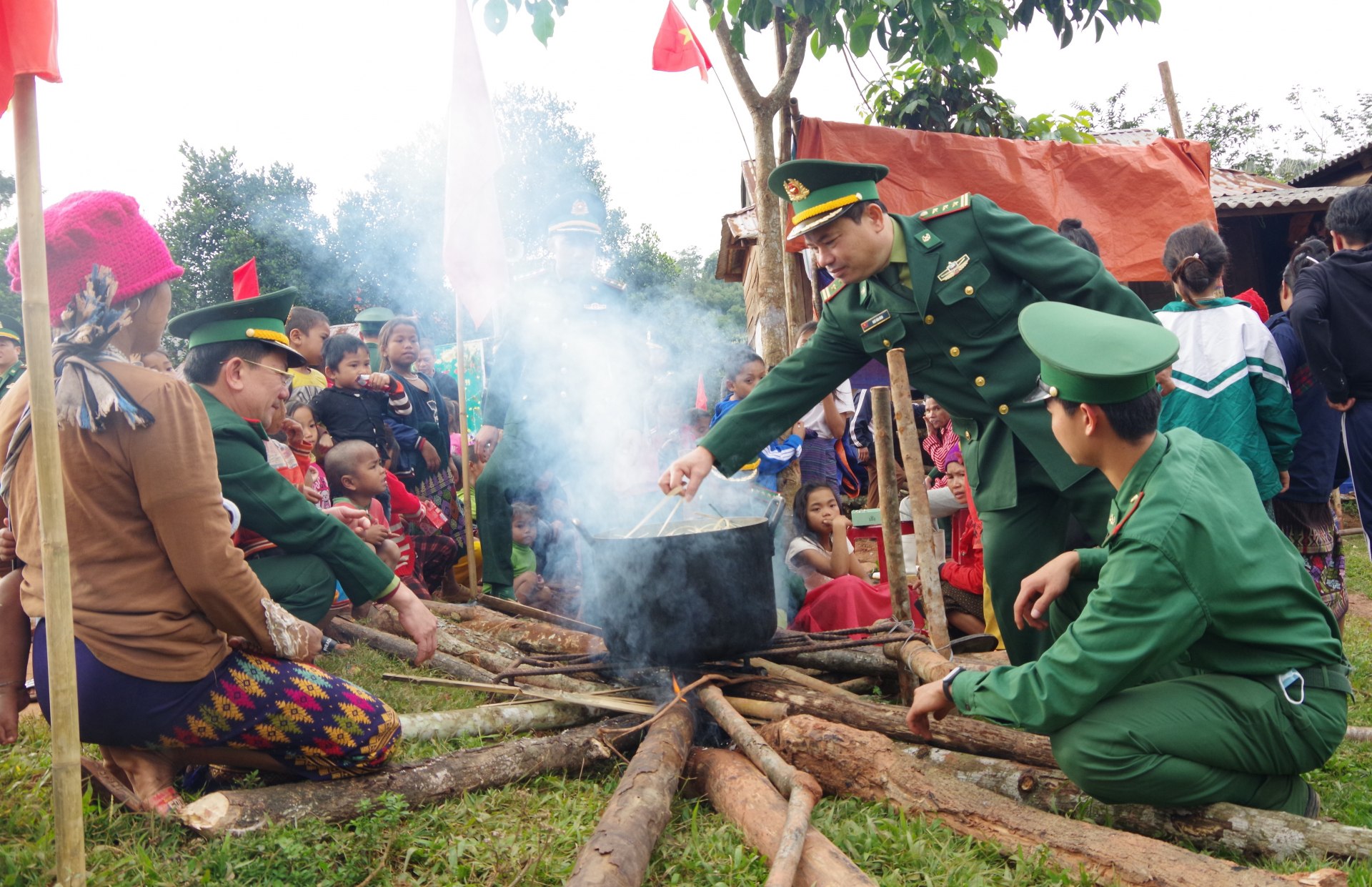 Cán bộ, chiến sĩ cùng bà con gói và nấu bánh chưng xanh tặng bà con vùng biên giới.