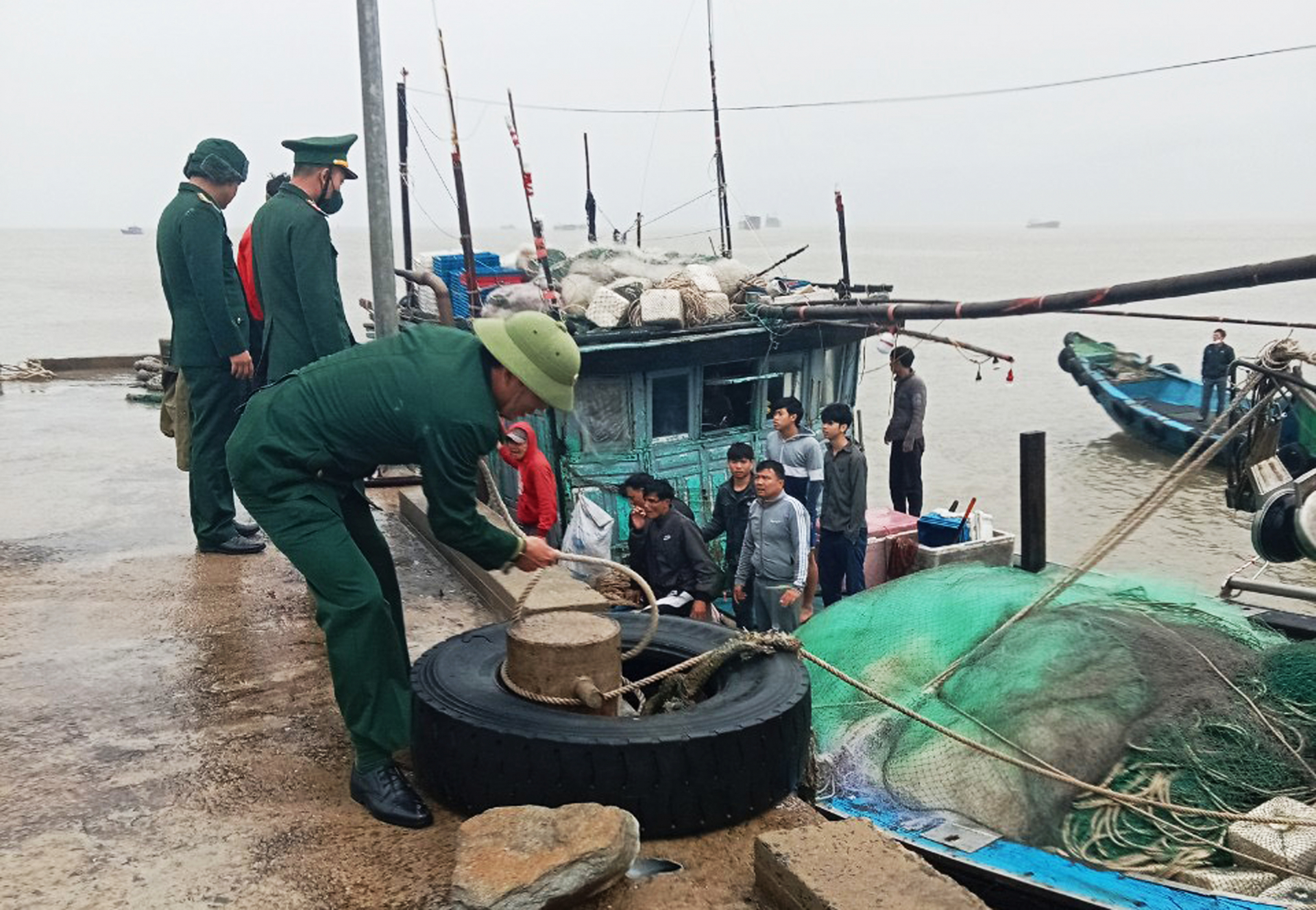 Cán bộ Đồn Biên phòng Roòn hỗ trợ tàu tàu QB-93055-TS cập cảng để tiếp nhận 08 ngư dân tàu QB-93153-TS.