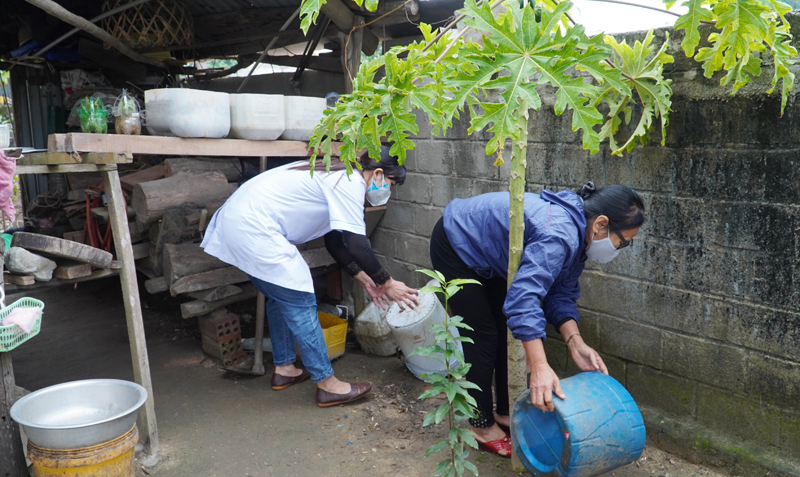 Cán bộ y tế hướng dẫn người dân vệ sinh môi trường tại nhà, diệt lăng quăng/bọ gậy.