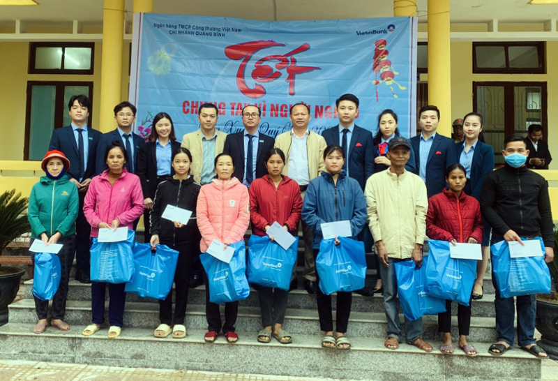 Đại diện Ngân hàng thương mại cổ phần Việt Nam chi nhánh Quảng Bình và lãnh đạo xã Trường Sơn trao quà Tết cho đồng bào