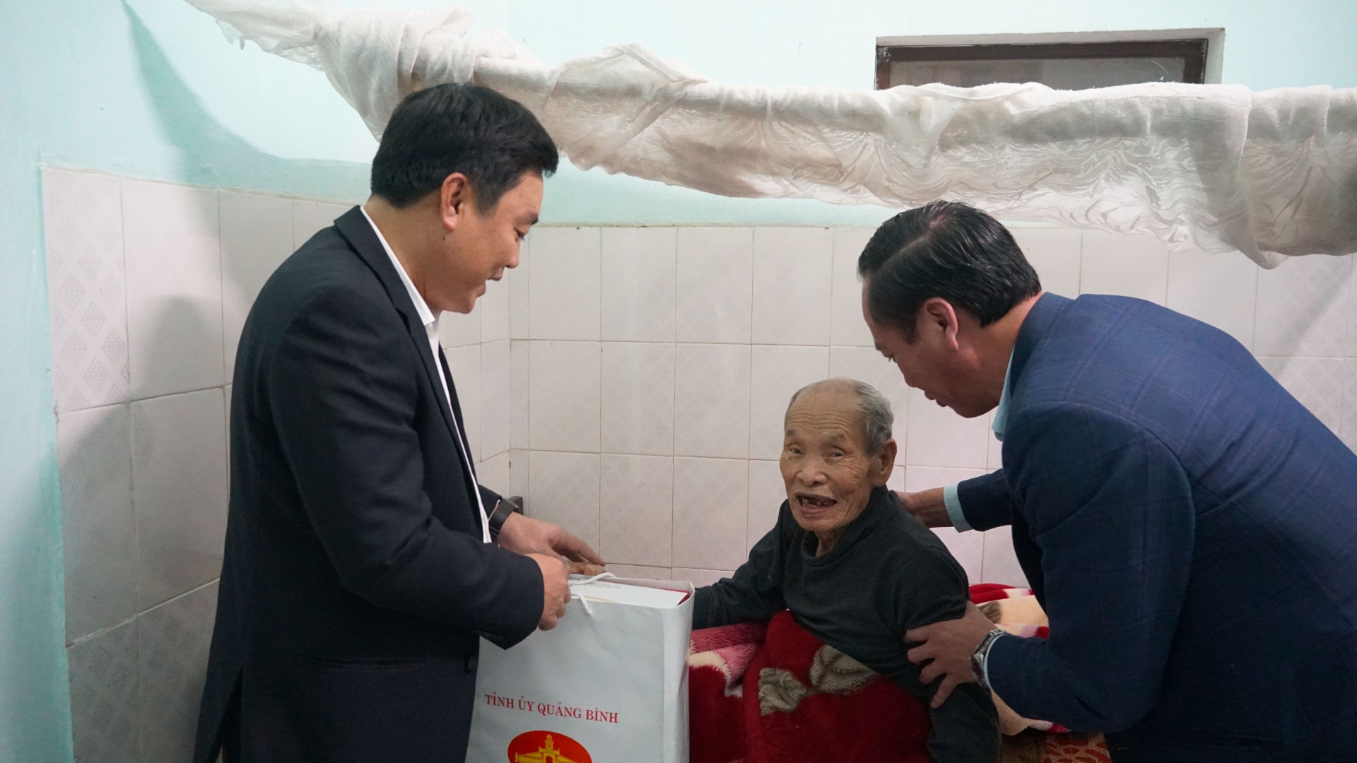 Đồng chí Chủ nhiệm Ủy ban Kiểm tra Tỉnh ủy Đinh Hữu Thành và Bí thư Huyện ủy Nguyễn Xuân Đạt ân cần hỏi thăm sức khỏe đảng viên lão thành Trần Tường. 