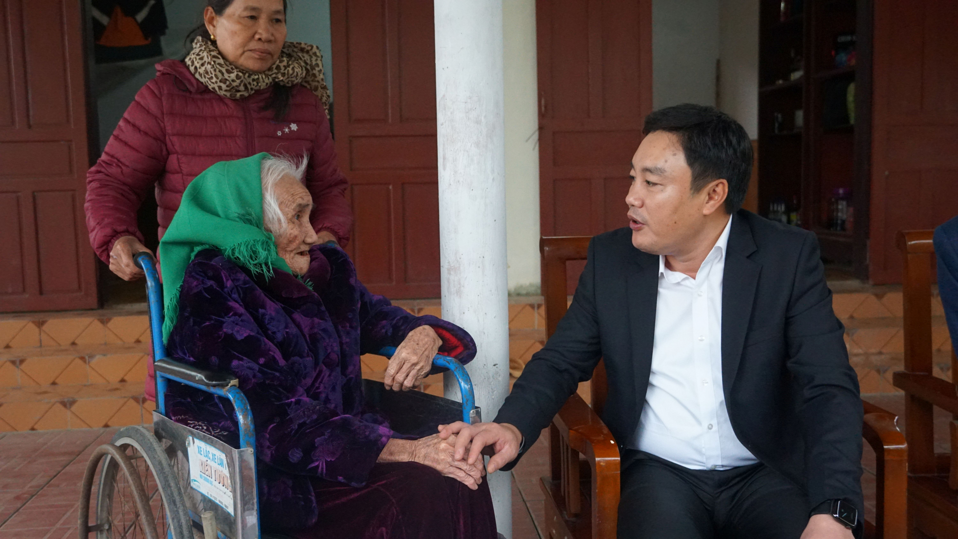 Đồng chí Chủ nhiệm Ủy ban Kiểm tra Tỉnh ủy Đinh Hữu Thành ân cần thăm hỏi sức khỏe đảng viên lão thành Trịnh Thị Nhụy.