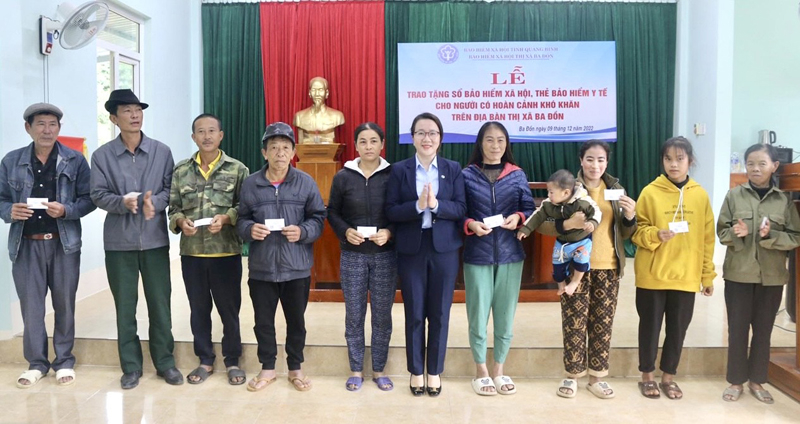 Đại diện lãnh đạo BHXH TX. Ba Đồn trao tặng thẻ BHYT cho người có hoàn cảnh khó khăn.