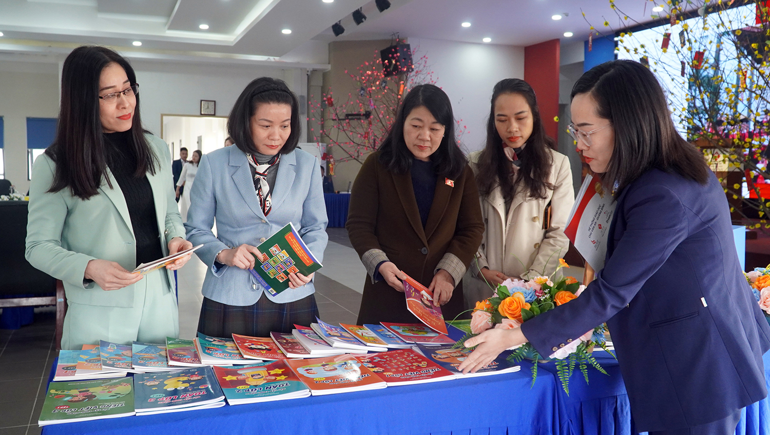 Đồng chí Nguyễn Minh Tâm và các đại biểu xem bộ sách giáo khoa do Thạc sĩ Đặng Thị Trà, Hiệu trưởng Trường tiểu học Chu Văn An biên soạn