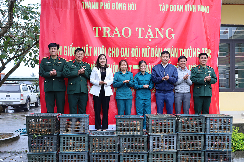 Đại diện một số ban, ngành thành phố và Tập đoàn Vĩnh Hưng trao con giống vật nuôi cho Đại đội nữ Dân quân thường trực Pháo phòng không 37mm.