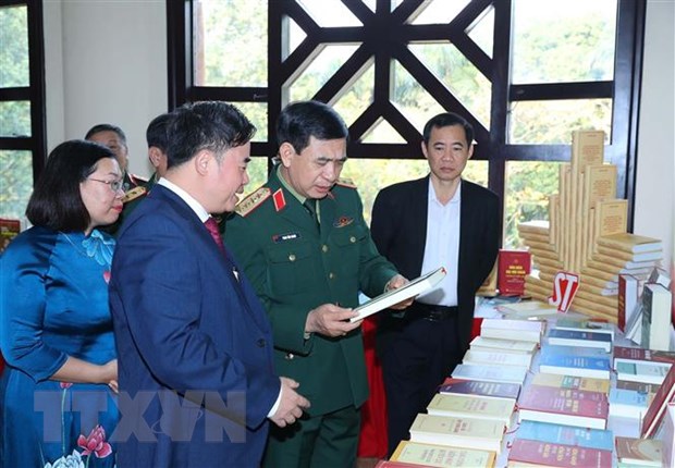 Bộ trưởng Bộ Quốc phòng Phan Văn Giang và các đại biểu xem gian trưng bày sách in và sách điện tử bên lề hội thảo. (Ảnh: Trọng Đức/TTXVN)