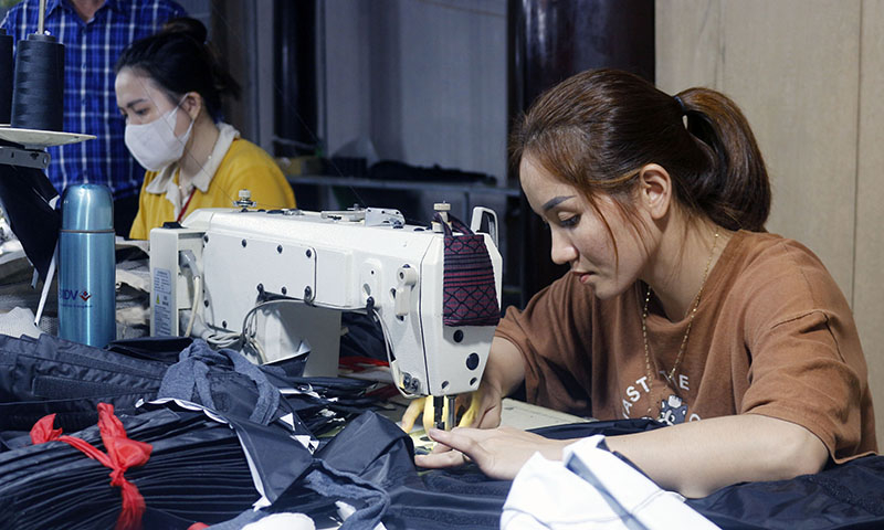 Những bàn tay của người nông dân vốn quen với ruộng đồng đã thôi lóng ngóng khi điều khiển máy may công nghiệp.