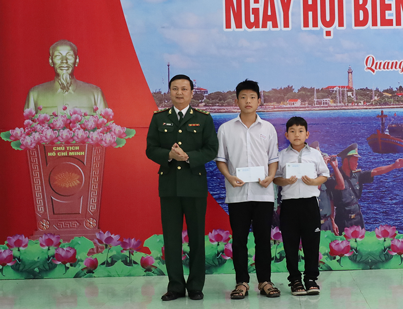Đại diện lãnh đạo Đồn Biên phòng Nhật Lệ trao học bổng  