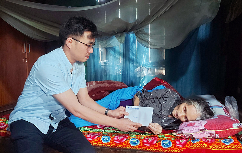 Phóng viên Báo Quảng Bình trao tiền hỗ trợ cho bà Đoàn Thị Thanh Tâm.