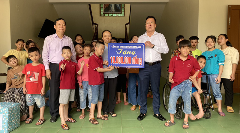 Đại diện Công ty TNHH thương mại ADB Quảng Bình, Hội Bảo trợ Người khuyết tật và trẻ mồ côi tỉnh tặng quà cho trẻ em và người già khuyết tật