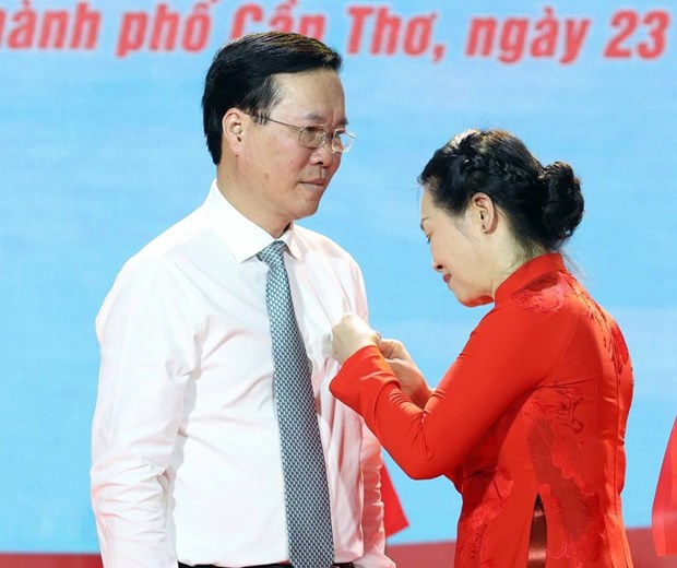 Bà Bùi Thị Hòa - Chủ tịch Hội Chữ thập Đỏ Việt Nam - gắn Huy hiệu Chữ thập Đỏ và tặng hoa chúc mừng Chủ tịch nước Võ Văn Thưởng làm Chủ tịch danh dự Hội Chữ thập Đỏ Việt Nam. (Ảnh: Thống Nhất/TTXVN)