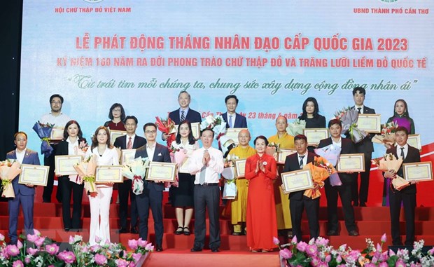 Chủ tịch nước Võ Văn Thưởng, Chủ tịch danh dự Hội Chữ thập Đỏ Việt Nam và bà Bùi Thị Hòa, Chủ tịch Hội Chữ thập Đỏ Việt Nam tặng hoa và trao bảng Ghi nhận tấm lòng vàng nhân đạo. (Ảnh: Thống Nhất/TTXVN)