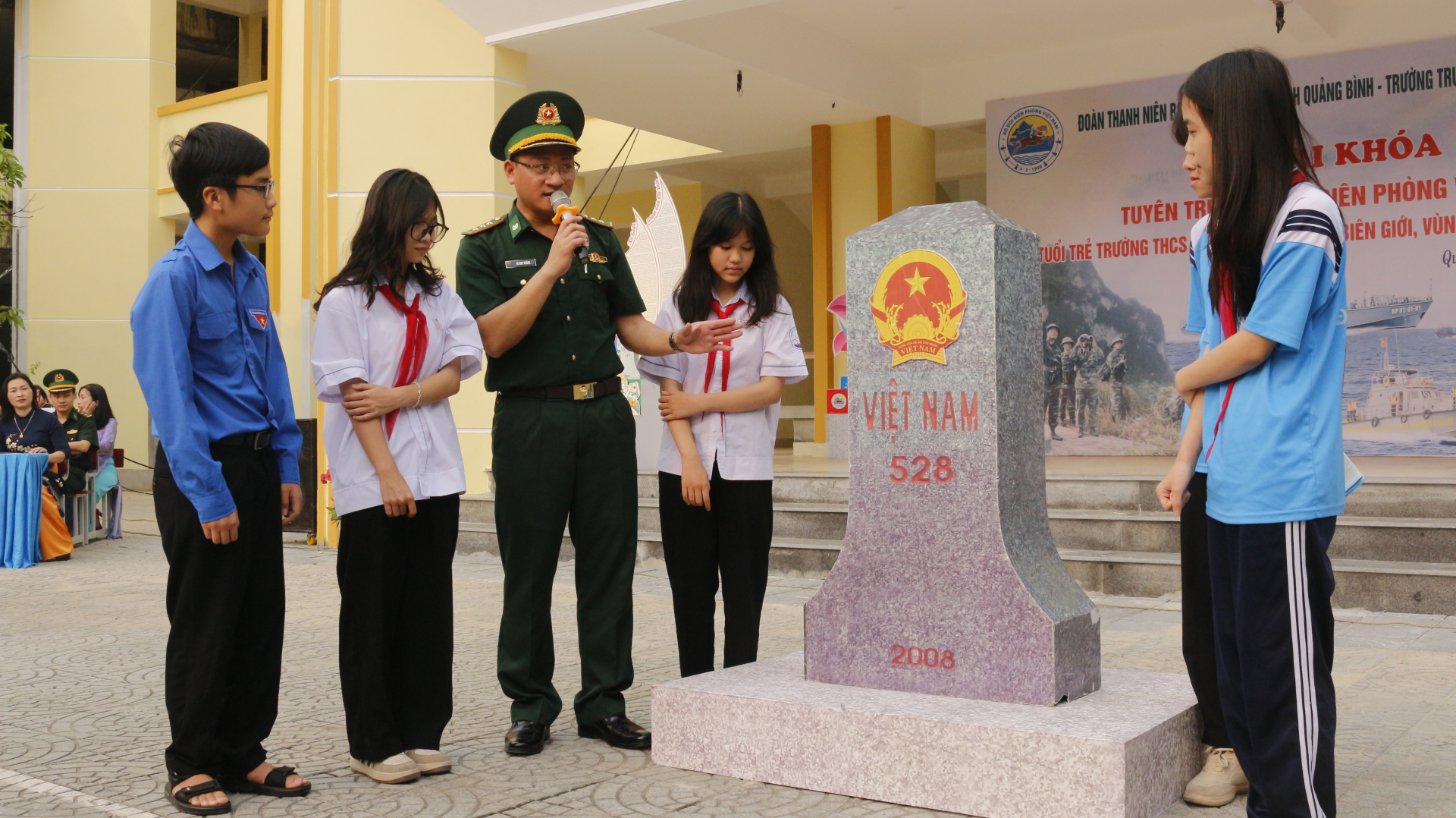 Thượng úy Võ Huy Thắng giới thiệu mô hình cột mốc quốc giới cho học sinh Trường THCS Đồng Mỹ (TP. Đồng Hới).