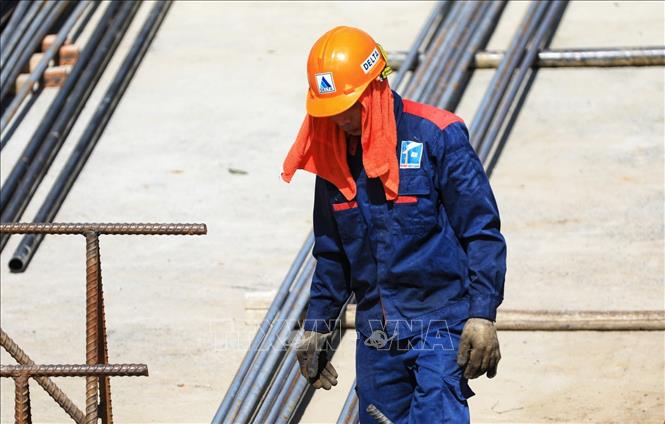 Công nhân làm việc tại các công trường phải dấp nước quấn khăn quanh đầu trước nắng nóng gay gắt có lúc lên hơn 40 độ C. Ảnh tư liệu: Thành Đạt/TTXVN